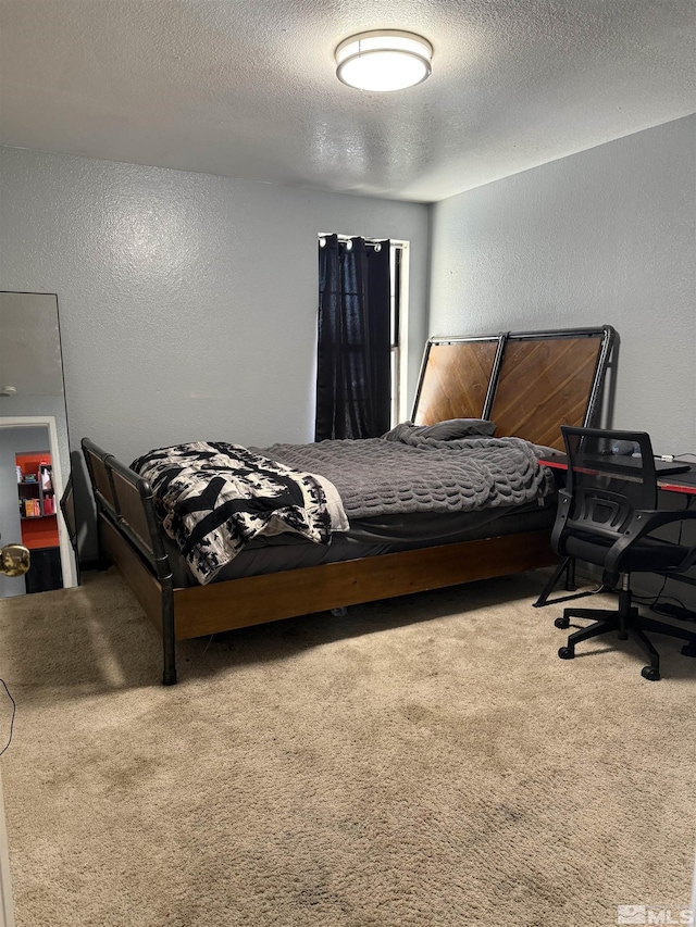 bedroom with carpet flooring, a textured ceiling, and a textured wall