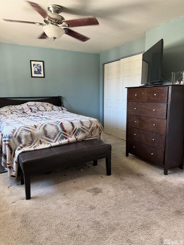 bedroom with a ceiling fan, light colored carpet, and a closet
