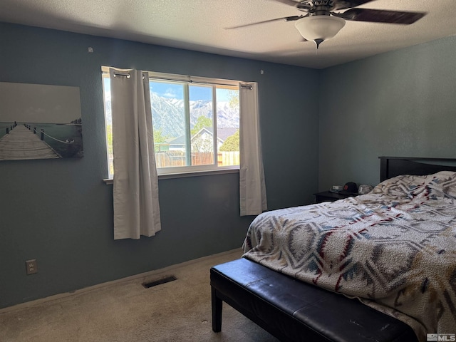 carpeted bedroom featuring a ceiling fan and visible vents