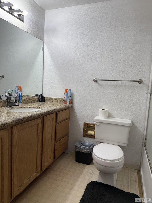 bathroom with tile patterned floors, baseboards, vanity, and toilet