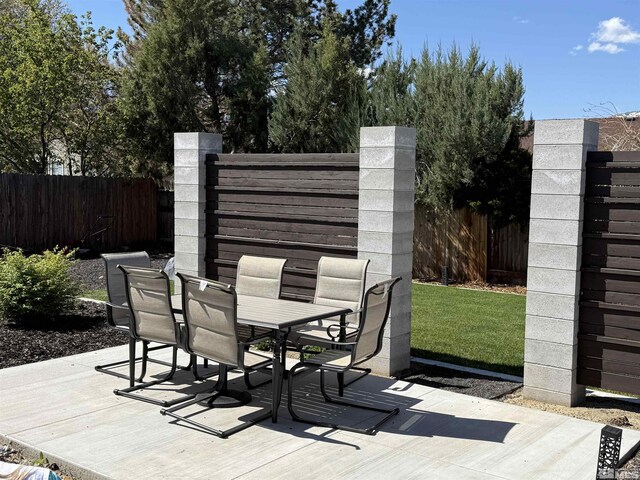 view of patio featuring outdoor dining area, fence, and a wooden deck