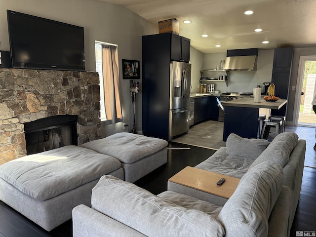 living area with recessed lighting, a fireplace, and light wood-type flooring