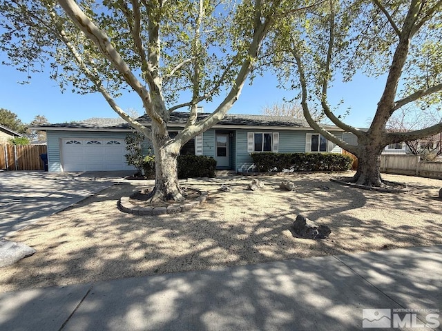 ranch-style house featuring concrete driveway, fence, and a garage