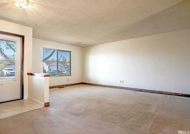 unfurnished room featuring carpet floors, a textured ceiling, and baseboards