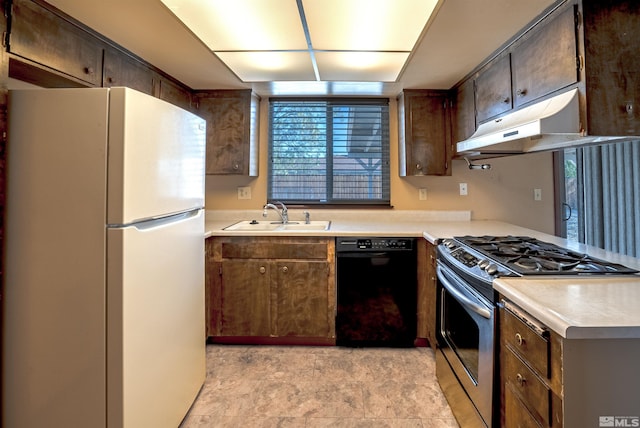kitchen featuring a sink, stainless steel gas range oven, dishwasher, light countertops, and freestanding refrigerator