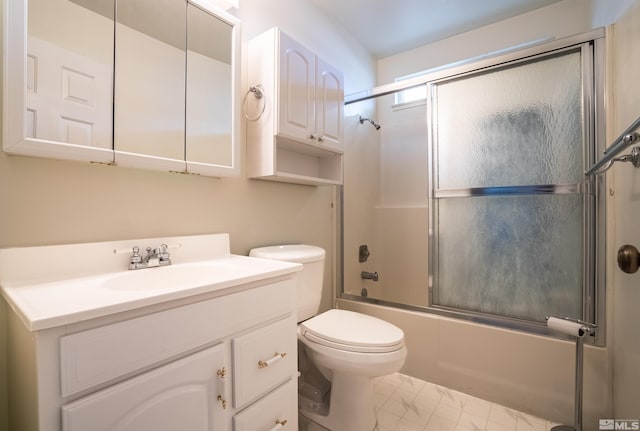 bathroom featuring toilet, enclosed tub / shower combo, marble finish floor, and vanity