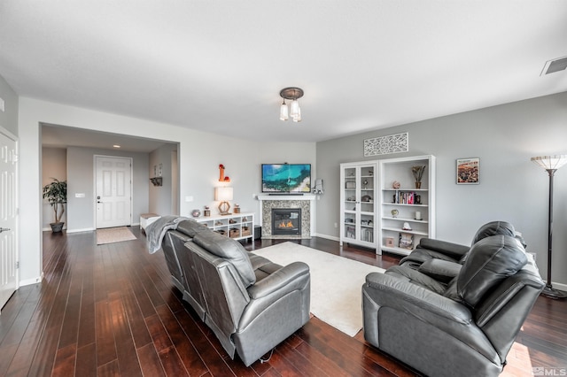 living room with visible vents, baseboards, dark wood-type flooring, and a tile fireplace