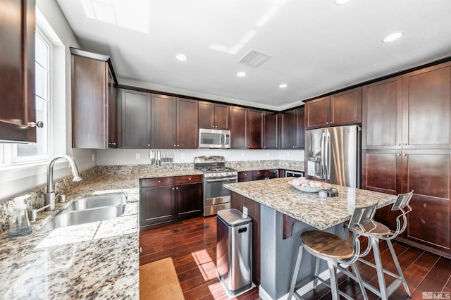 kitchen featuring visible vents, a sink, dark wood-style flooring, and stainless steel appliances