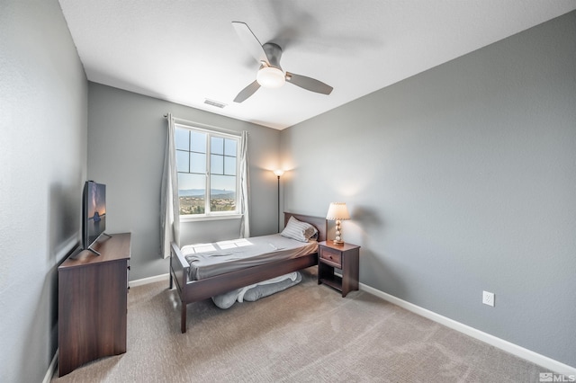carpeted bedroom with visible vents, a ceiling fan, and baseboards