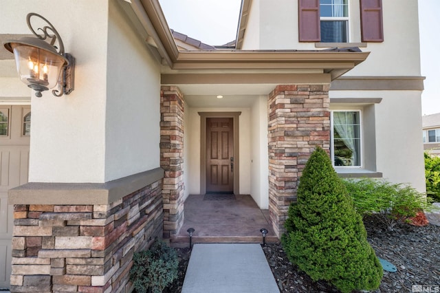 view of exterior entry with stucco siding and stone siding