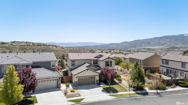 exterior space featuring a residential view, fence, stone siding, stucco siding, and driveway