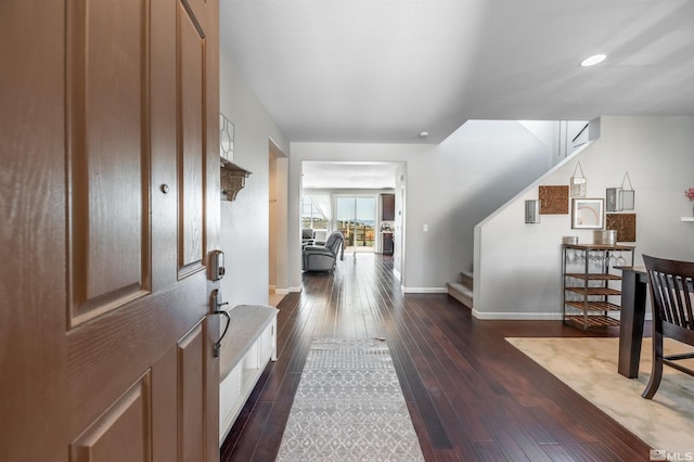 entrance foyer featuring stairs, baseboards, and dark wood-style floors