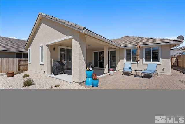 back of property featuring a patio, fence private yard, and stucco siding