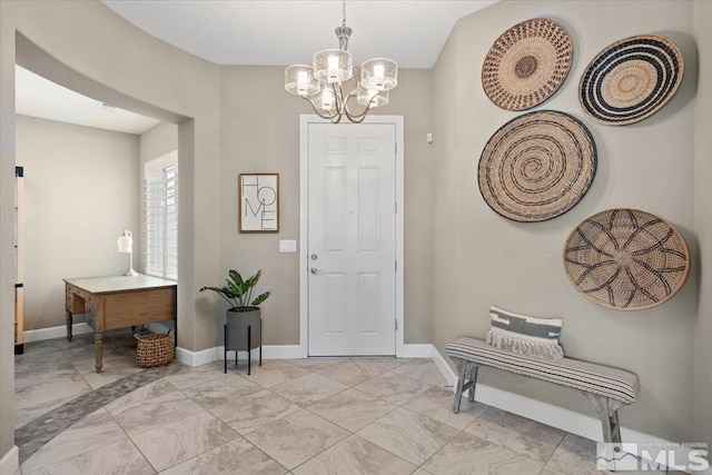 entryway with baseboards, a chandelier, and marble finish floor
