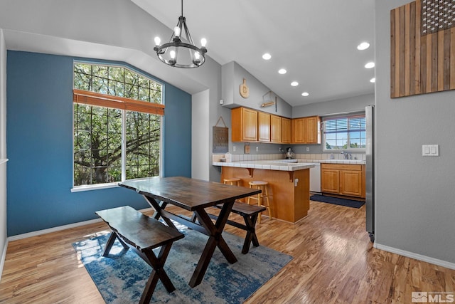 dining area with recessed lighting, light wood-style flooring, baseboards, and a notable chandelier