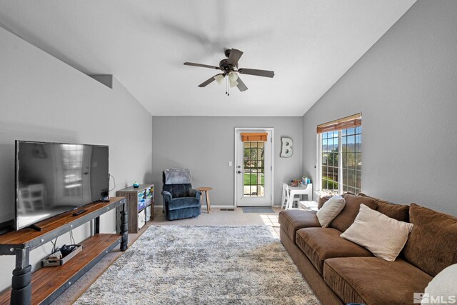 living room with baseboards, a ceiling fan, carpet flooring, and lofted ceiling
