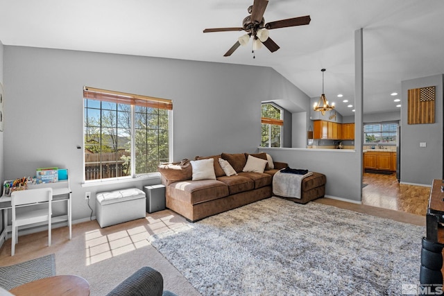 living room with light colored carpet, baseboards, ceiling fan with notable chandelier, and lofted ceiling