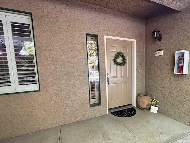 property entrance with stucco siding