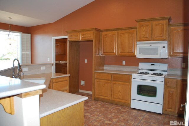kitchen featuring white appliances, decorative light fixtures, lofted ceiling, and light countertops