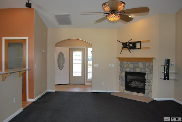 entrance foyer with visible vents, light carpet, a fireplace, baseboards, and ceiling fan