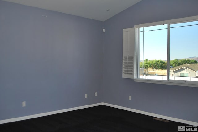 unfurnished room featuring baseboards and vaulted ceiling