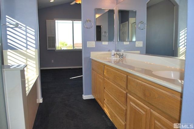 full bath with double vanity, a ceiling fan, baseboards, and a sink