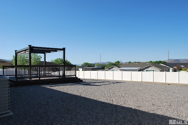 exterior space with fence, cooling unit, and a deck