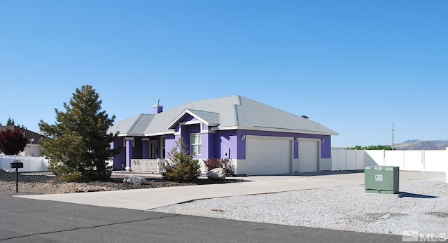 single story home featuring an attached garage, fence, and driveway