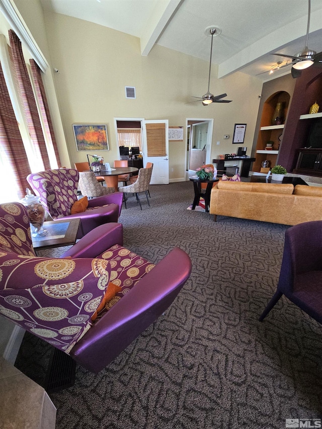 carpeted living room featuring ceiling fan, beam ceiling, and built in shelves