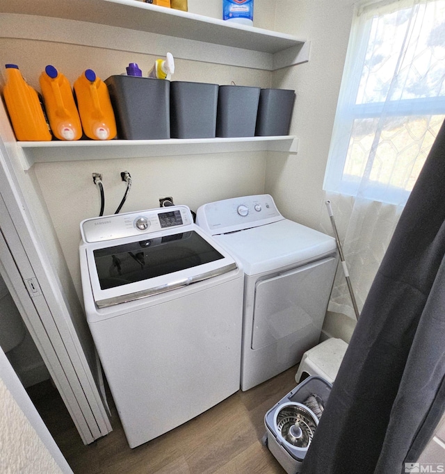 washroom with washing machine and clothes dryer and wood finished floors