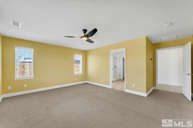 unfurnished room with visible vents, carpet flooring, baseboards, and a ceiling fan