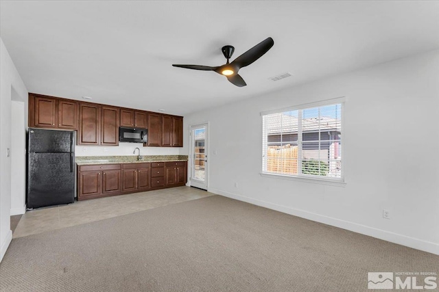 kitchen with a ceiling fan, baseboards, and black appliances