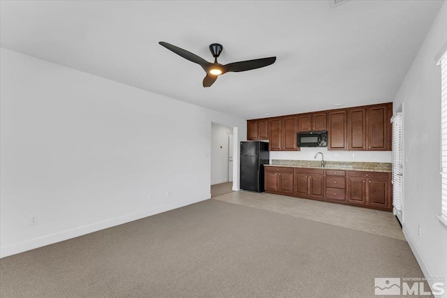 kitchen featuring ceiling fan, light colored carpet, light countertops, baseboards, and black appliances