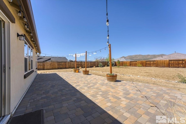 view of patio featuring a mountain view and a fenced backyard
