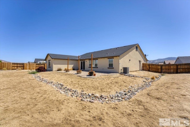rear view of house with central air condition unit, a patio, a fenced backyard, and stucco siding