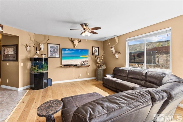 living room featuring baseboards, ceiling fan, and hardwood / wood-style floors