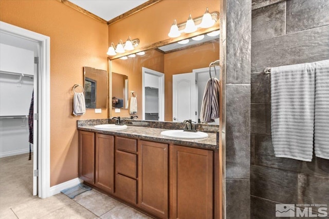 bathroom featuring a sink, tile patterned flooring, double vanity, and a spacious closet