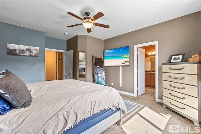 bedroom with baseboards, light carpet, ceiling fan, and ensuite bath