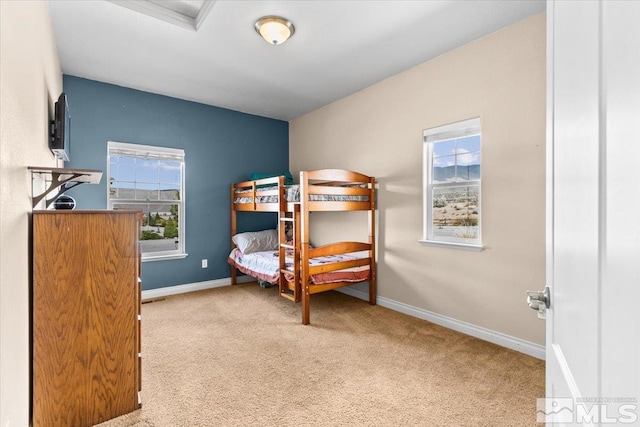 bedroom with baseboards, carpet flooring, and multiple windows