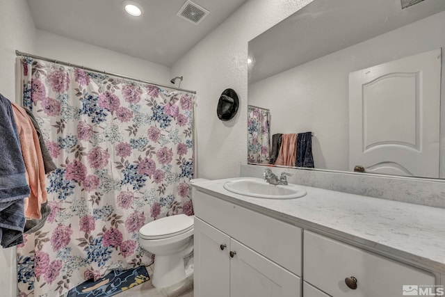 full bathroom with vanity, a shower with shower curtain, toilet, and visible vents