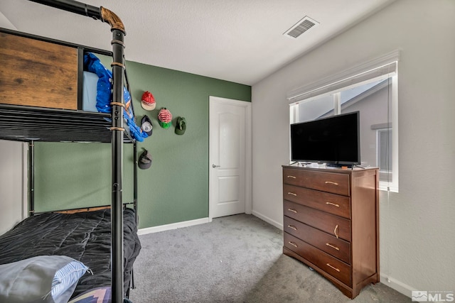 carpeted bedroom featuring baseboards and visible vents
