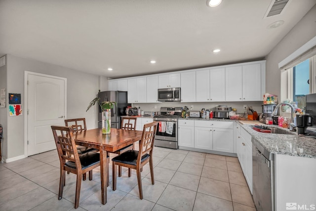 kitchen featuring visible vents, a sink, white cabinetry, and stainless steel appliances