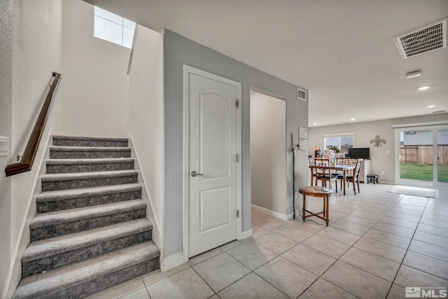 stairs featuring tile patterned floors, baseboards, recessed lighting, and visible vents