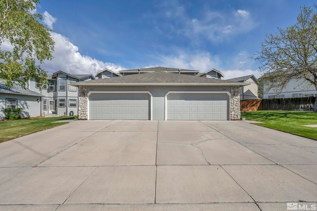 view of front of home with fence, a garage, concrete driveway, stone siding, and a front lawn