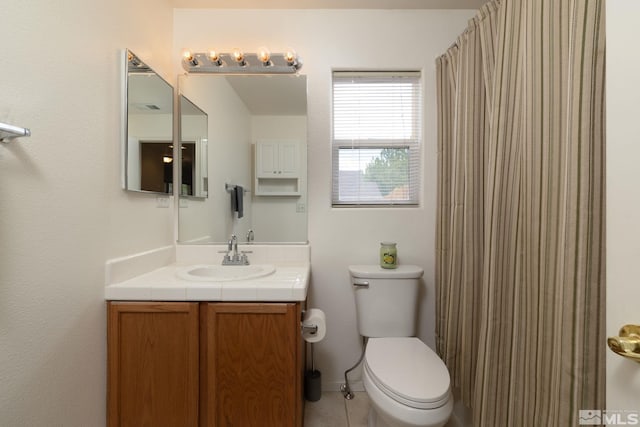 bathroom with curtained shower, vanity, toilet, and tile patterned floors