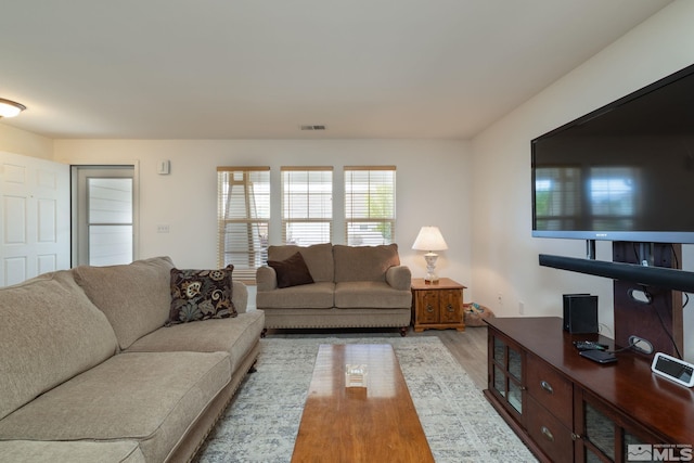 living area featuring visible vents and wood finished floors