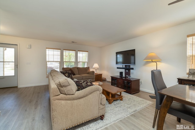 living room with ceiling fan, baseboards, a healthy amount of sunlight, and wood finished floors