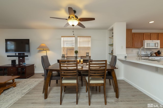 dining room featuring a ceiling fan, recessed lighting, baseboards, and light wood-type flooring