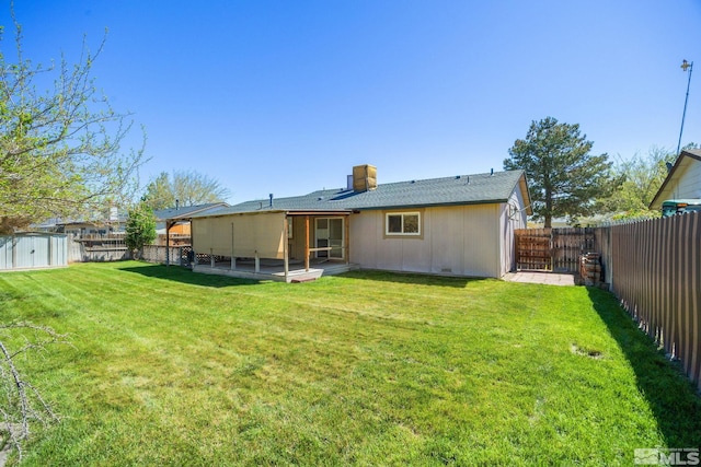 rear view of property with a storage shed, an outbuilding, a patio area, and a chimney