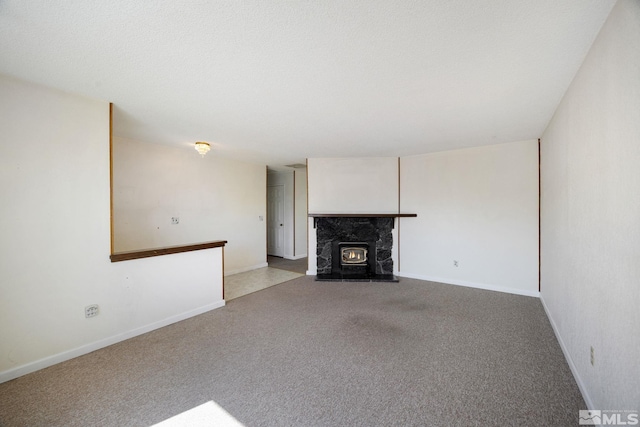 unfurnished living room featuring carpet, a premium fireplace, and baseboards